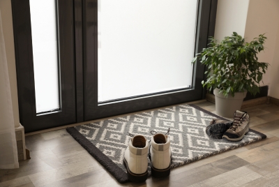 Wet winter boots on mat protecting carpet in Illinois entryway