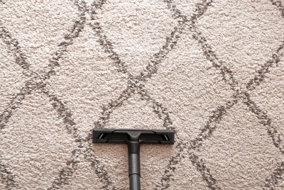 Vacuuming carpet to maintain cleanliness and extend lifespan